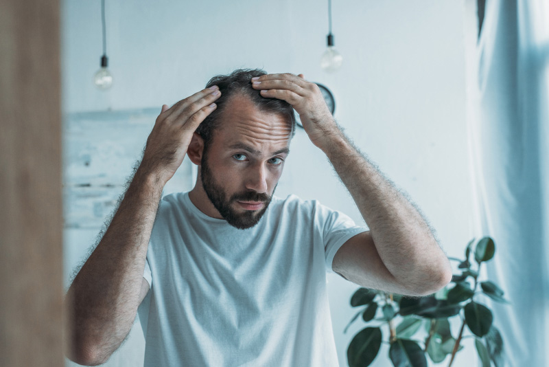 Younger man checking his hairline